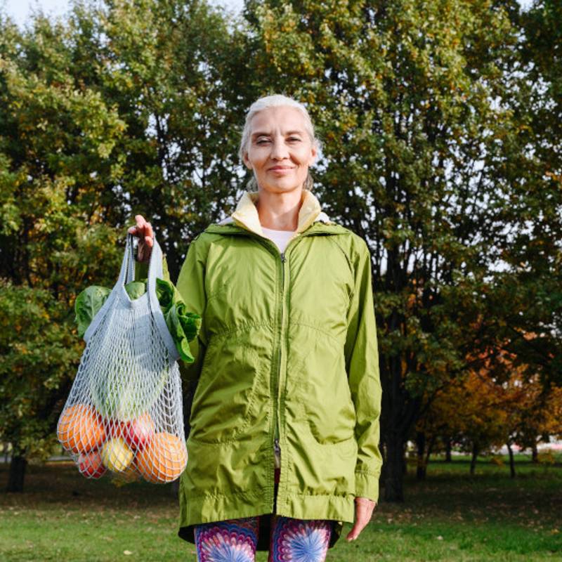 woman holding bag of fruit