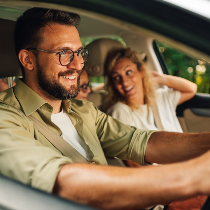 father driving family in car