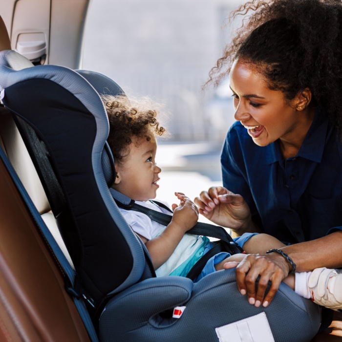 mother putting child in car seat