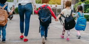a group of young school children holding hands