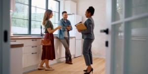 young couple viewing house with estate agent