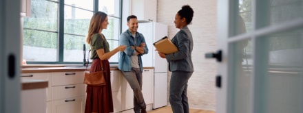 young couple viewing house with estate agent
