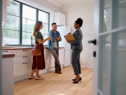 young couple viewing house with estate agent