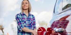 woman putting petrol in car