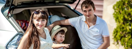 family sitting at back of car