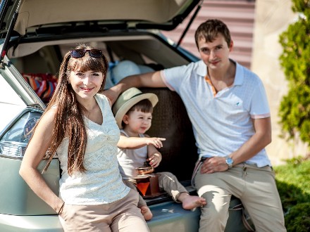 family sitting at back of car