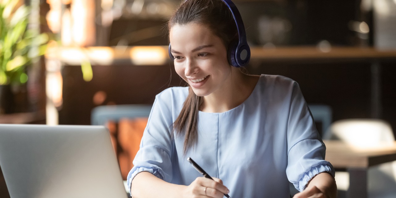 young woman on laptop with headfones