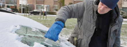 man deicing his car windscreen
