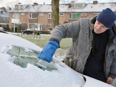 man deicing his car windscreen