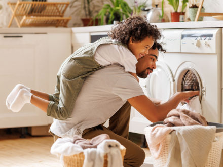 father with son doing laundry
