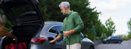 Man holding power cable at ev charging station