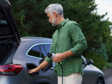 Man holding power cable at ev charging station