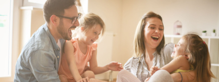 father and mother playing with two daughters