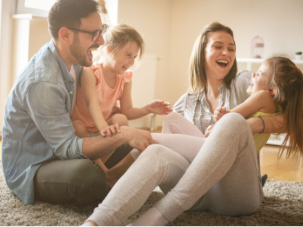 father and mother playing with two daughters