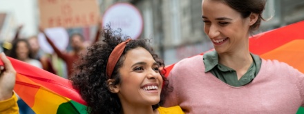 Young gay couple with pride flag