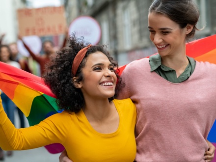 Young gay couple with pride flag