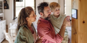couple at home setting thermostat