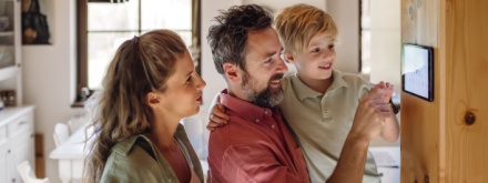 couple at home setting thermostat