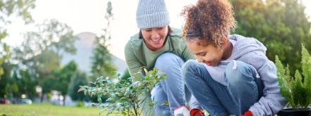 mother and daughter planting a tree