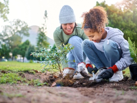 mother and daughter planting a tree