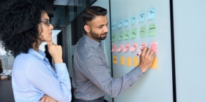 male and female office workers using whiteboard