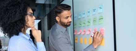 male and female office workers using whiteboard