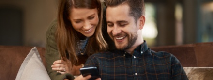 couple at home on laptop and phone