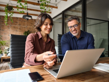 male and female office workers at laptop