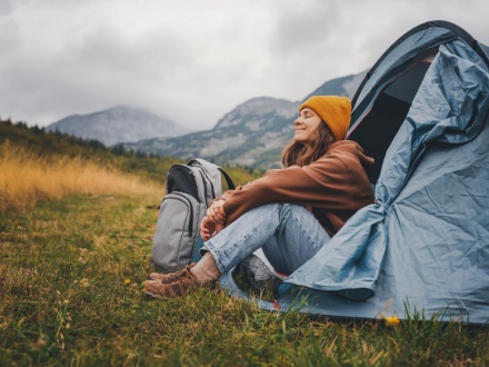 woman camping in blue tent