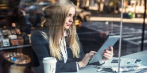 woman reading newspaper in coffee shop