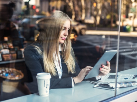 woman reading newspaper in coffee shop