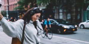 Young woman on city street with headphones on
