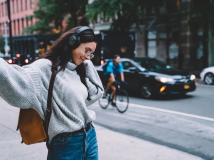 Young woman on city street with headphones on