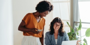 two woman in office looking at laptop