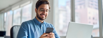 Smiling man on phone at office desk