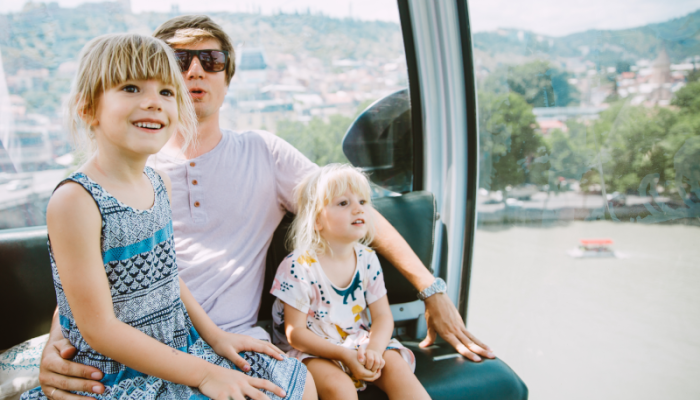 father and two daughters in a cable car