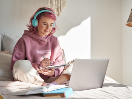 hipster teenager in bedroom studying