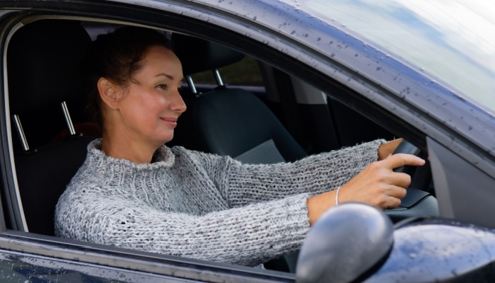 smiling woman driving car