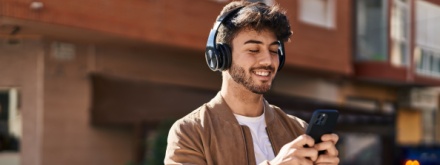 young man with headphones and phone in hand