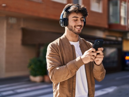 young man with headphones and phone in hand
