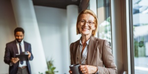 older female office worker with male colleague in the background