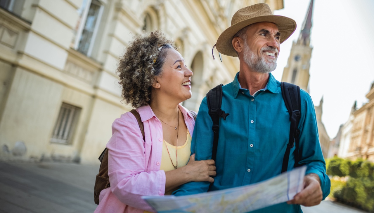 Middle aged couple on city break reading a map