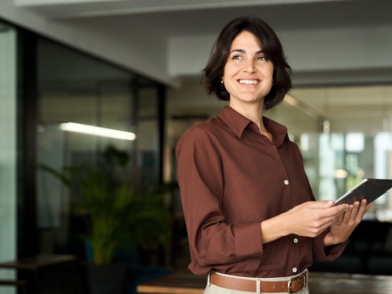 Hispanic woman in office on tablet