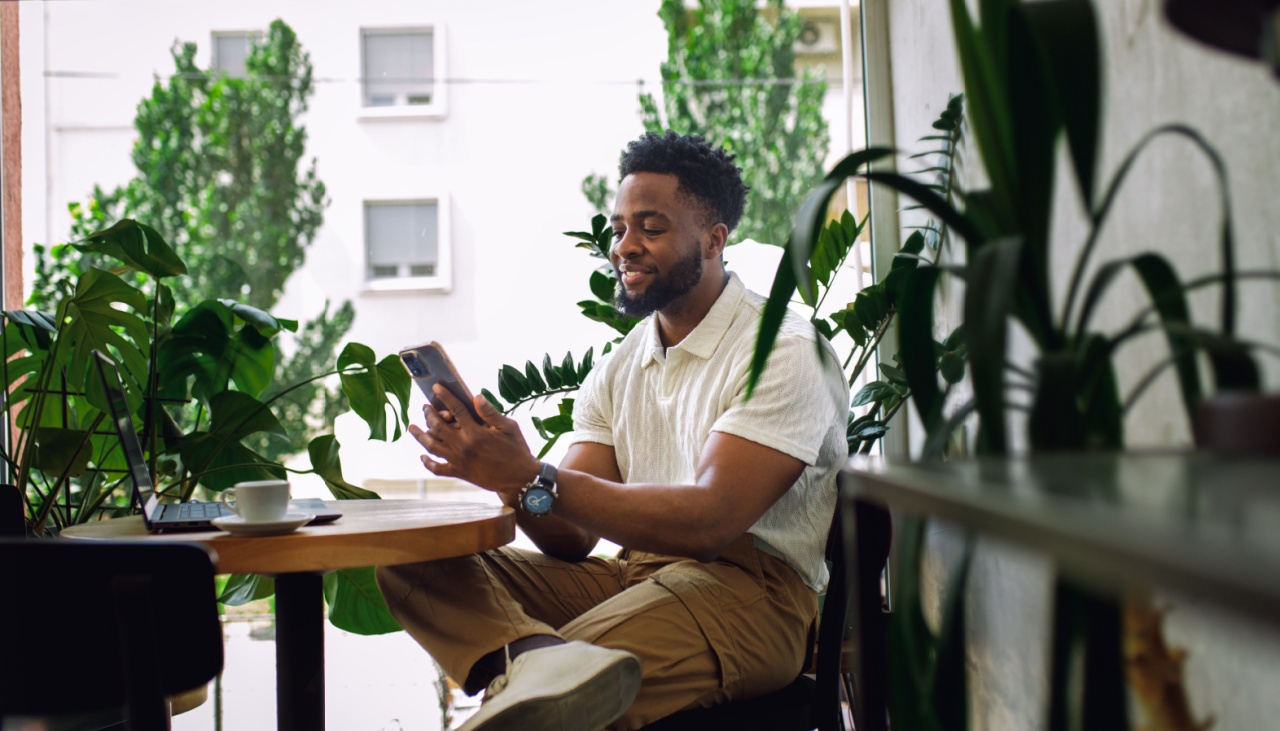 man in coffee shop surrounded by plants