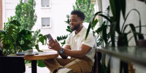 man in coffee shop surrounded by plants