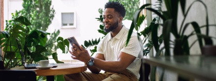 man in coffee shop surrounded by plants