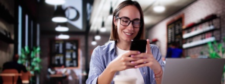 student in coffee shop on phone