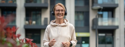 older woman walking with headphones