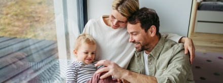 young family at home sitting by the window