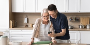 Grown up son spend time with mother in kitchen